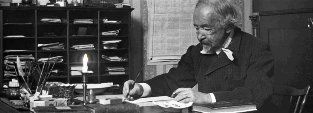 Topelius skriver vid sitt skrivbord. Ett sterainljus flimrar svagt.