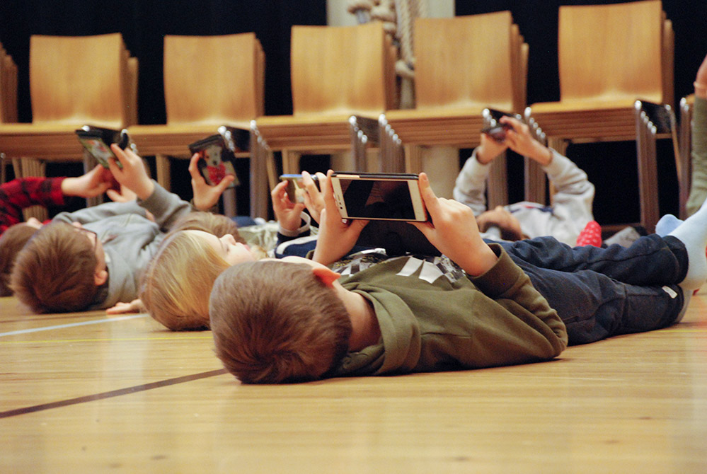 BArnopera: barn på golvet med telefoner
