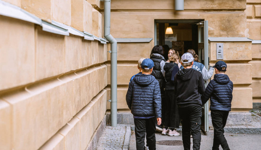 Barn i 8-9 årsåldern går in i skolan efter en rast.