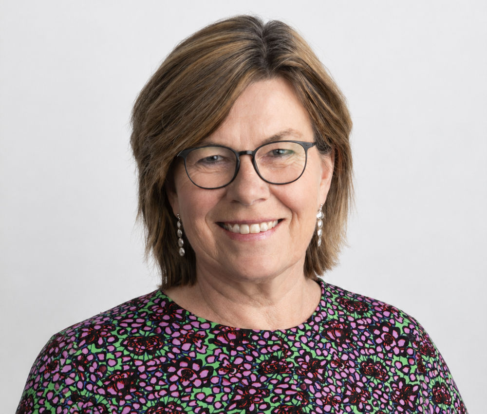 På bilden syns en medelålders kvinna vid namn Britt Lundberg. Hon har brunt hår som är klippt i en sorts pagefrisyr. Hon har tunna märka glasögon, ser rakt in i kameran och ler. Hon har silverörhängen och en blus med litet mönster i vinrött, grönt och svart. Bakgrunden är neutralt grå.