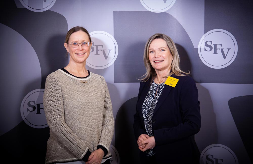 Erika Löfström och Mirjam Kalland leende framför en fondvägg med SFV:s logo. Bilden togs under SFV Start-finalen.