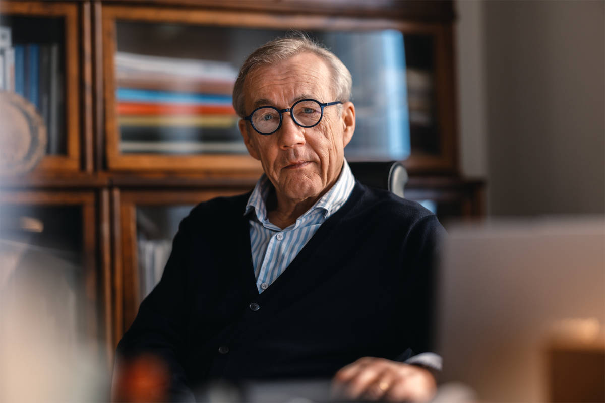 Sixten Korkamn sitter vid sitt skrivbord. Bakom honom ser man bokhyllor.